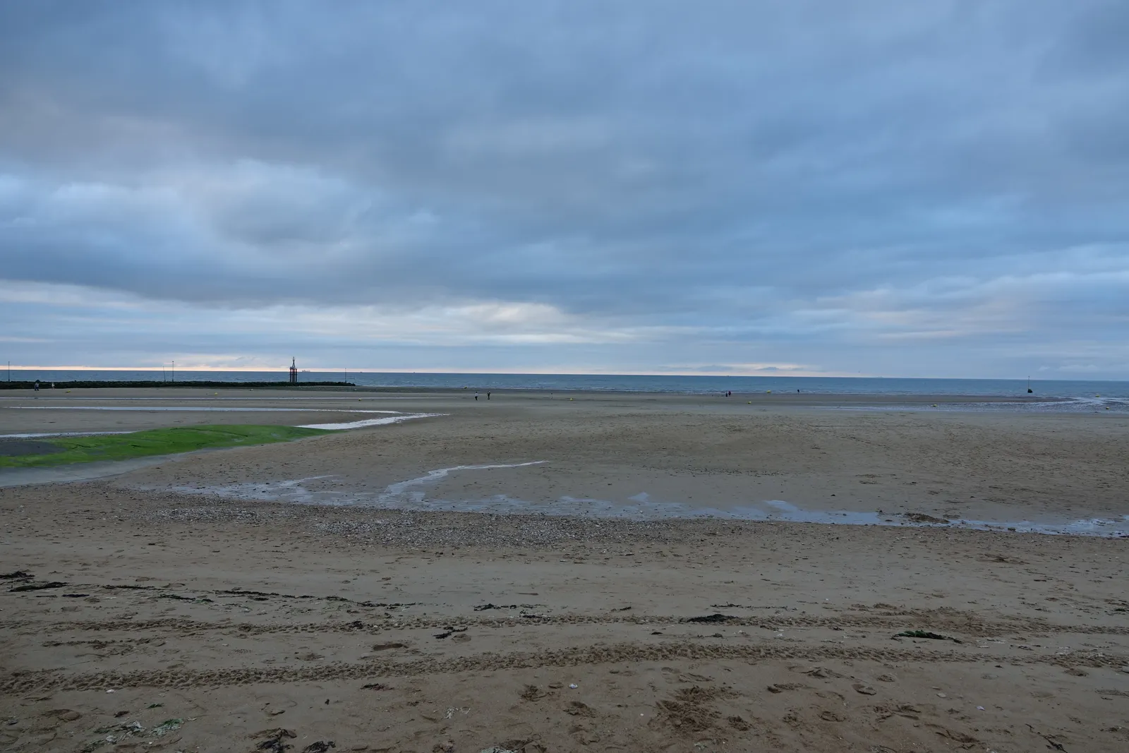 La plage de Juno Beach à Courseulles-sur-Mer à marée basse, avec le mémorial à l'horizon